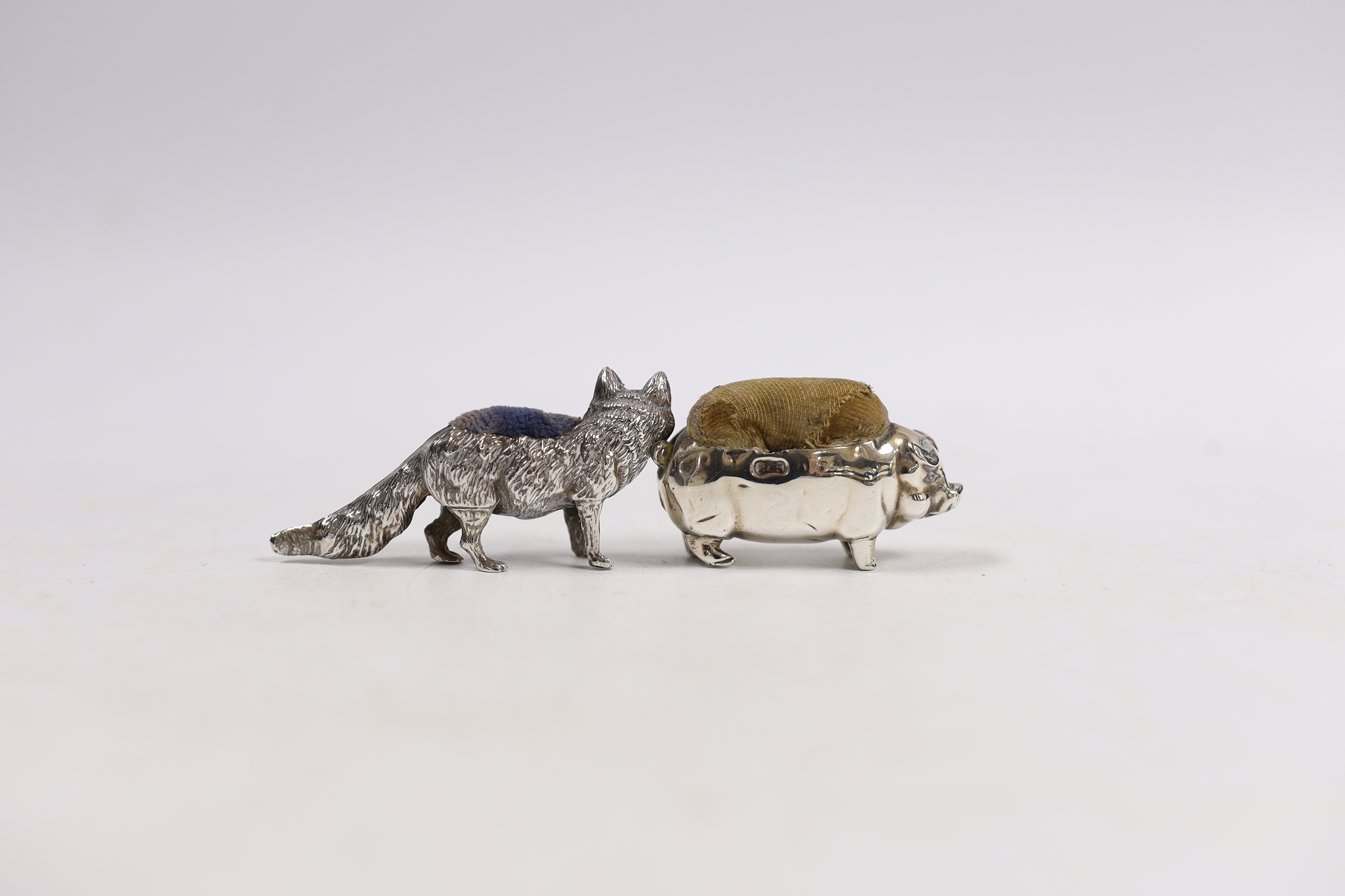 Two early 20th century novelty silver pin cushions, modelled as a fox, Levy & Salaman, Birmingham, 1905, length 60mm and a pig, same maker, marks rubbed.